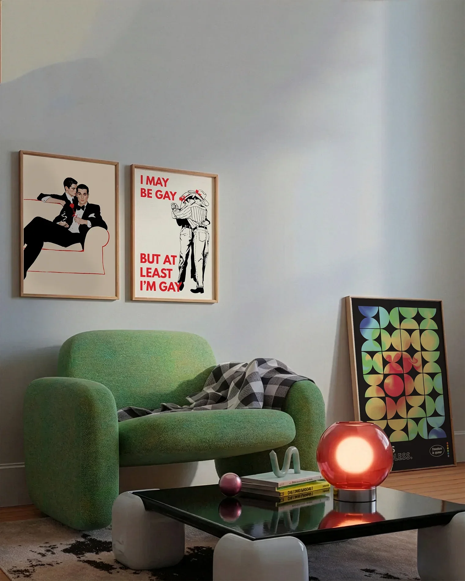 A gallery wall with several framed, queer posters in a living room.