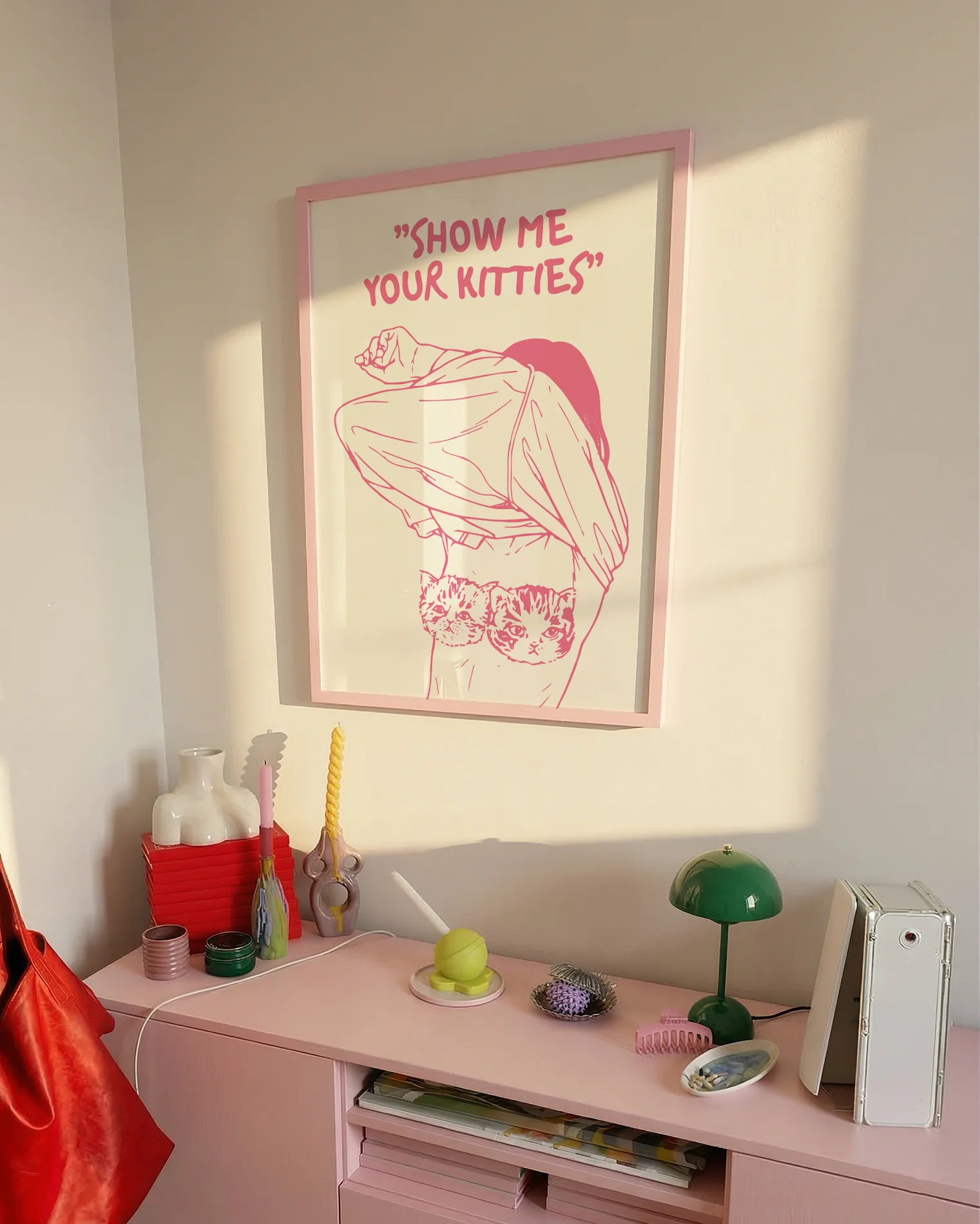 A poster of a woman removing her shirt with the text "SHOW ME YOUR KITTIES".