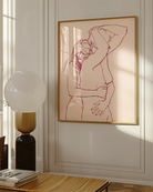 A framed print with two lesbian, naked girls hugging.