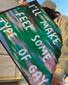 A poster with the text 'I'LL MAKE YOU FEEL SOME TYPE OF GAY', against an abstract landscape.