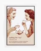 A framed poster featuring two women gossiping over tea, accompanied by the text: “Spilling The Tea – Verb – The act of sharing new or sensitive information, often exchanged in trusted queer company.”