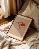 A framed poster with a lesbian couple sleeping under a blanket, sketch style.