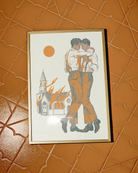 A framed poster depicting two gay men dancing in front of a burning church.
