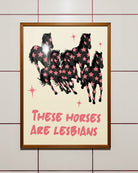 A framed poster with five horses and the text 'THESE HORSES ARE LESBIANS'.