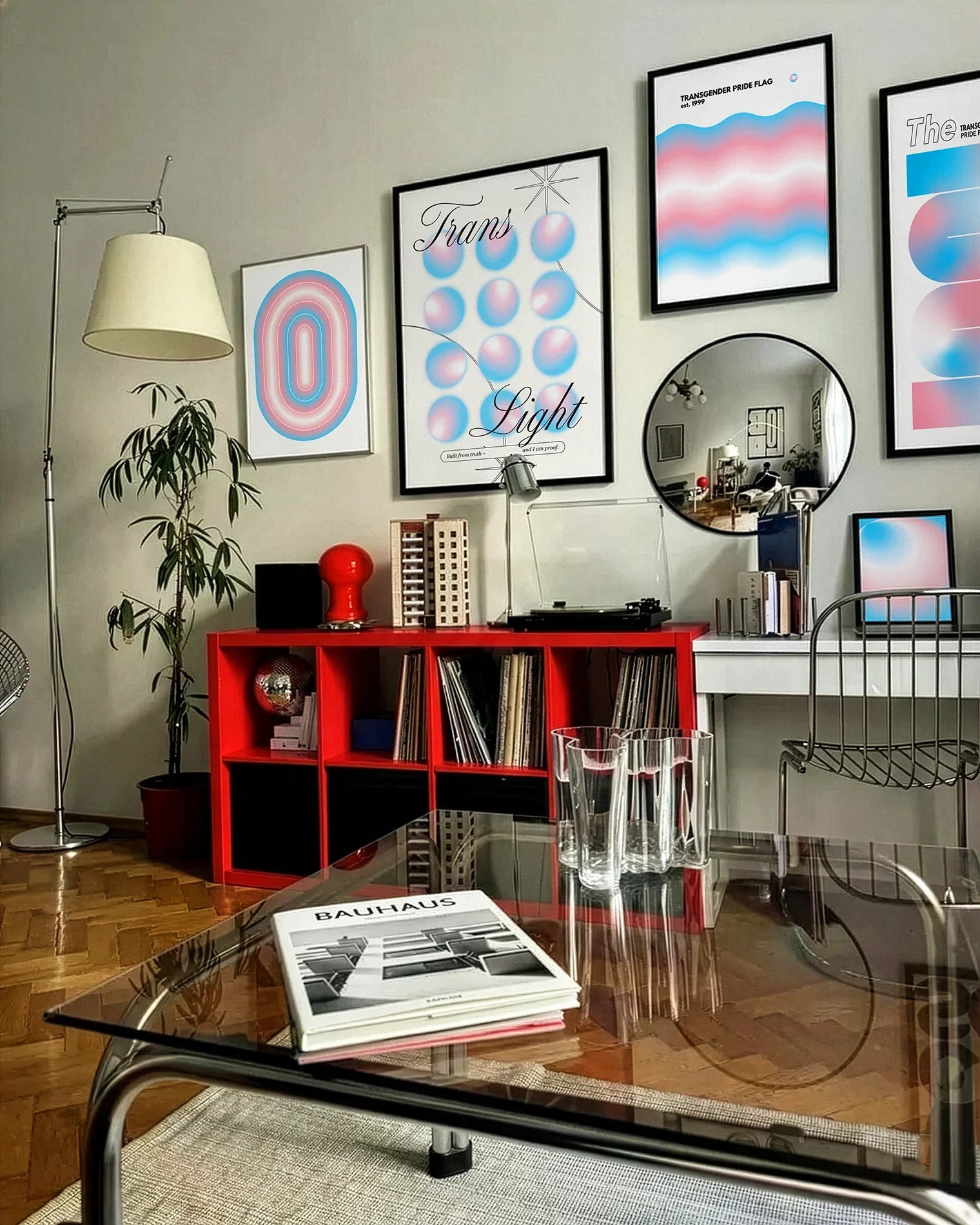 A gallery wall with several framed, transgender posters in a living room.