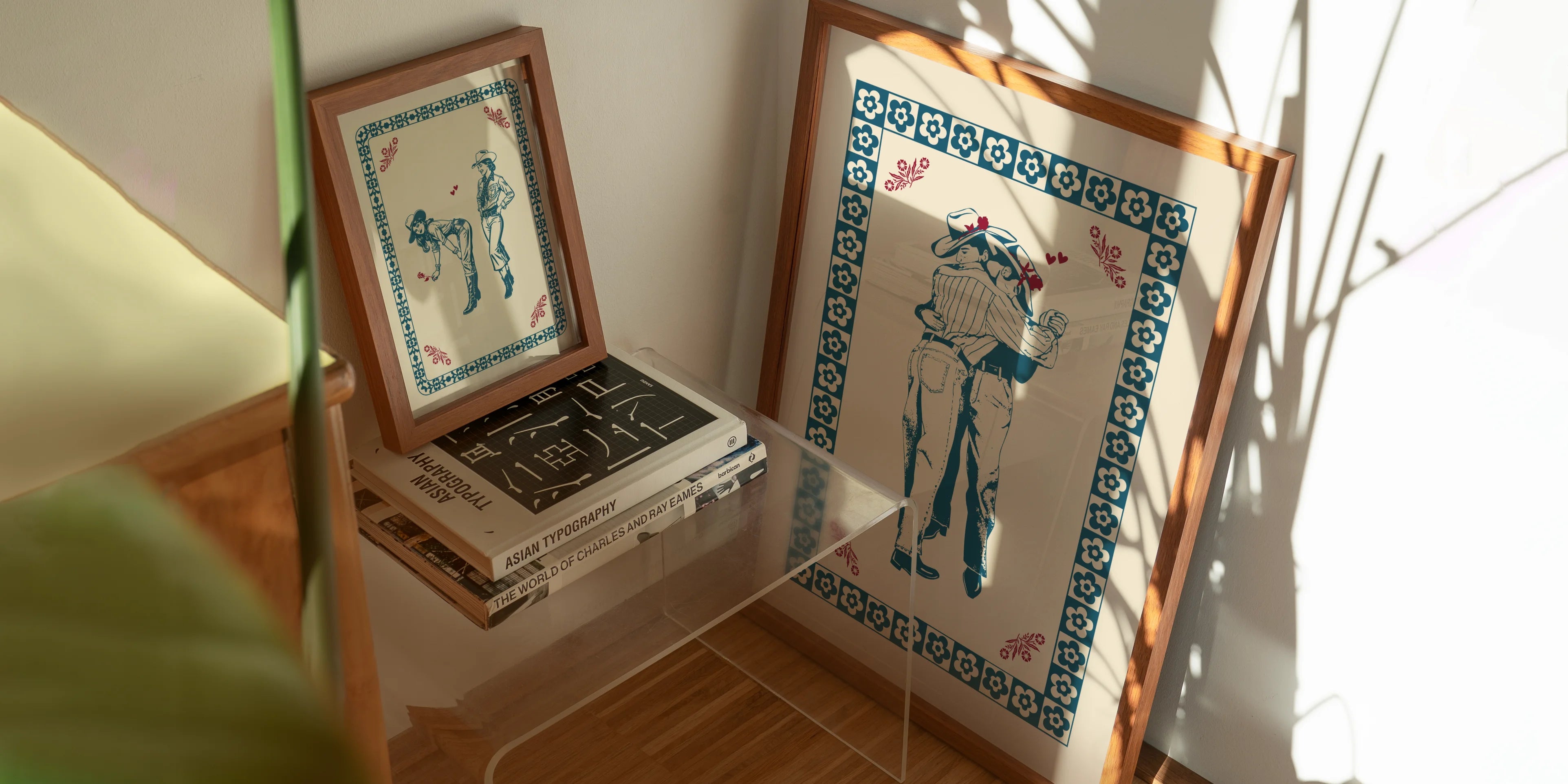 An image of two framed posters with queer cowboys and cowgirl couples.